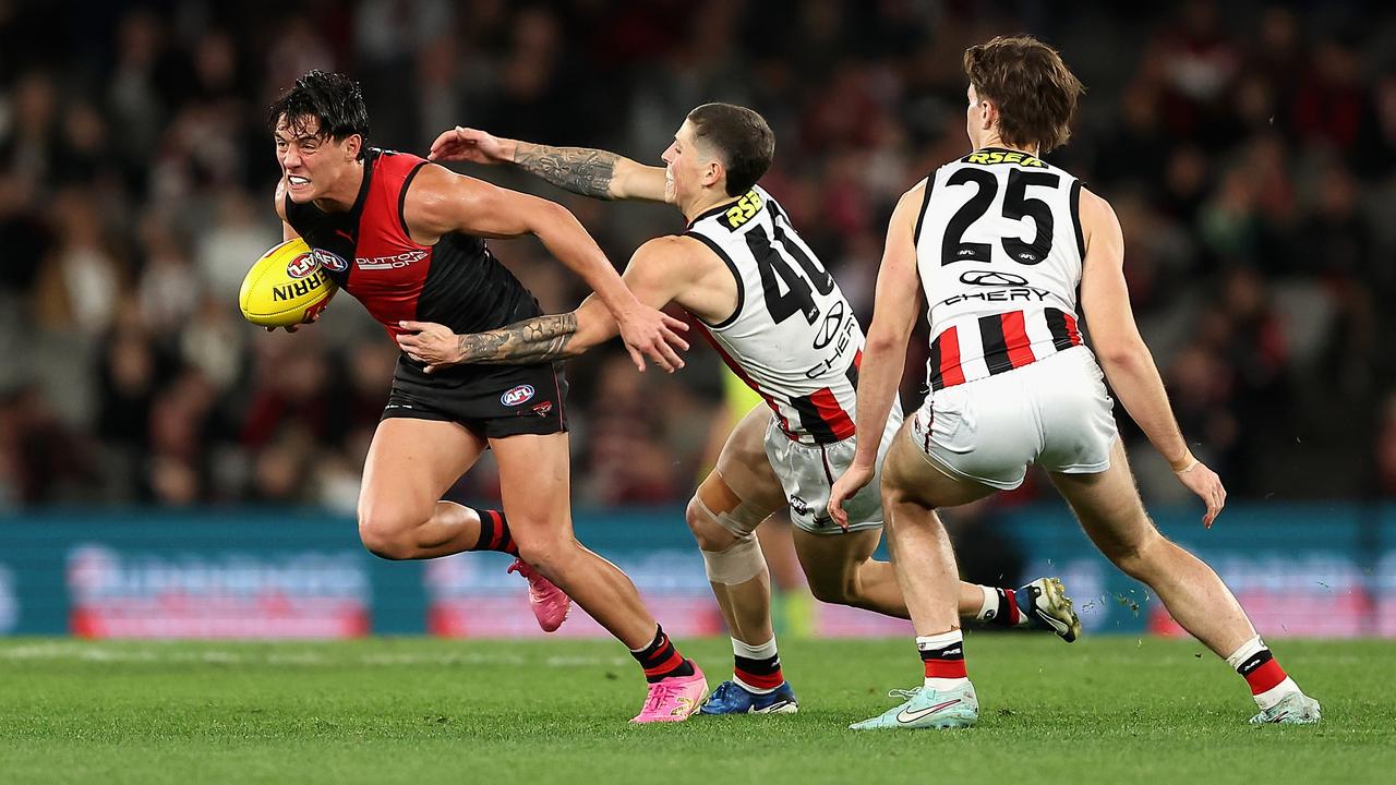 Essendon's Jye Caldwell tries to break free from a Max Hall tackle.