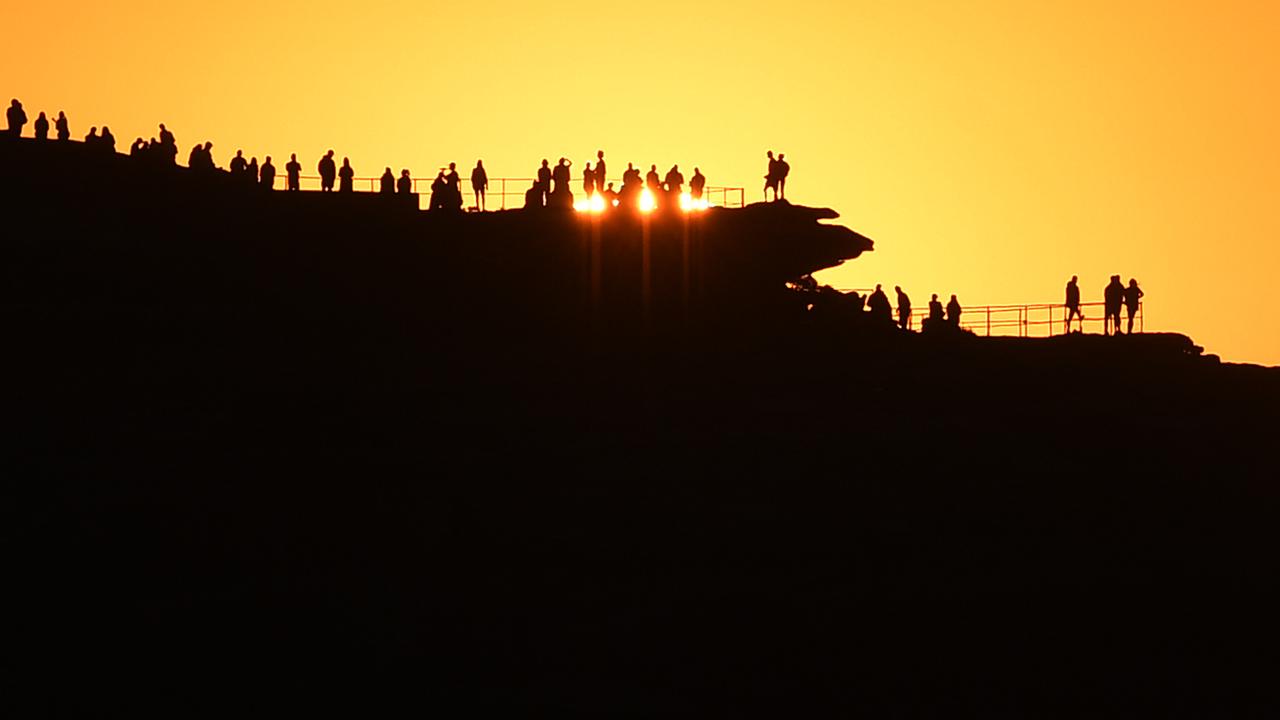People watch sunrise at Bondi Beach in Sydney, NSW