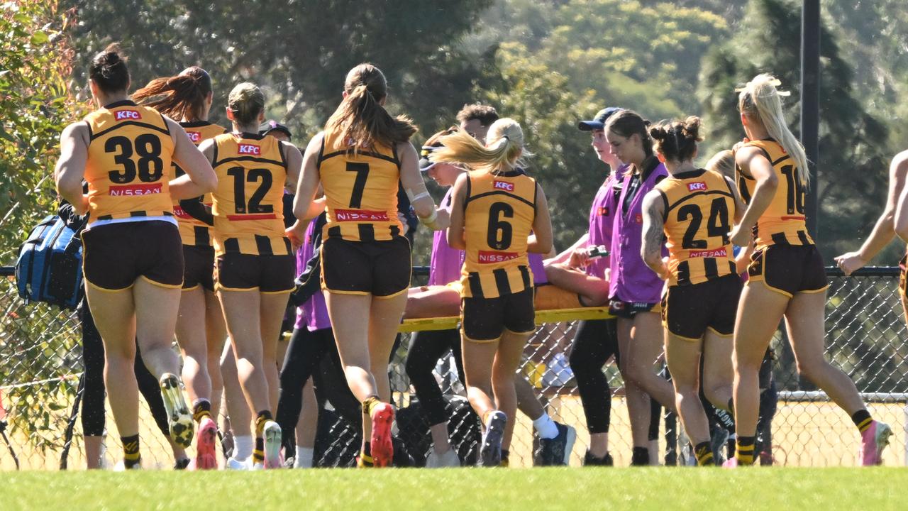 Teammates gathered around Hawthorn's Emily Bates.