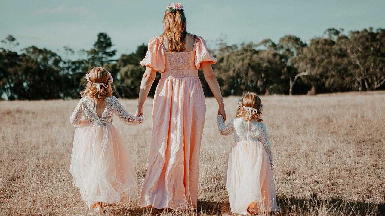 A Victorian woman in a field with her two children