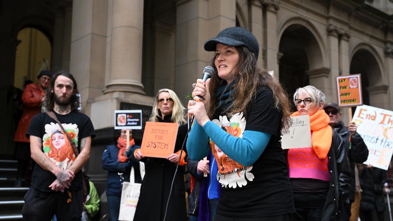 woman holds microphone in front of rally