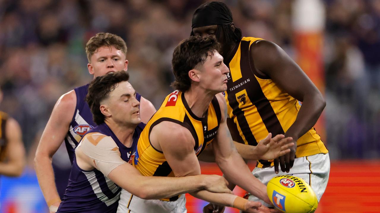 Fremantle's Jordan Clark applies a tackle to Hawk Connor Macdonald