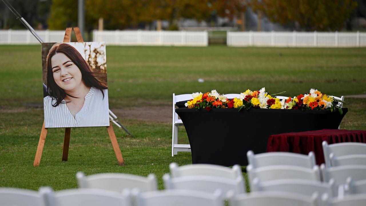 portrait of woman on easel next to flowers