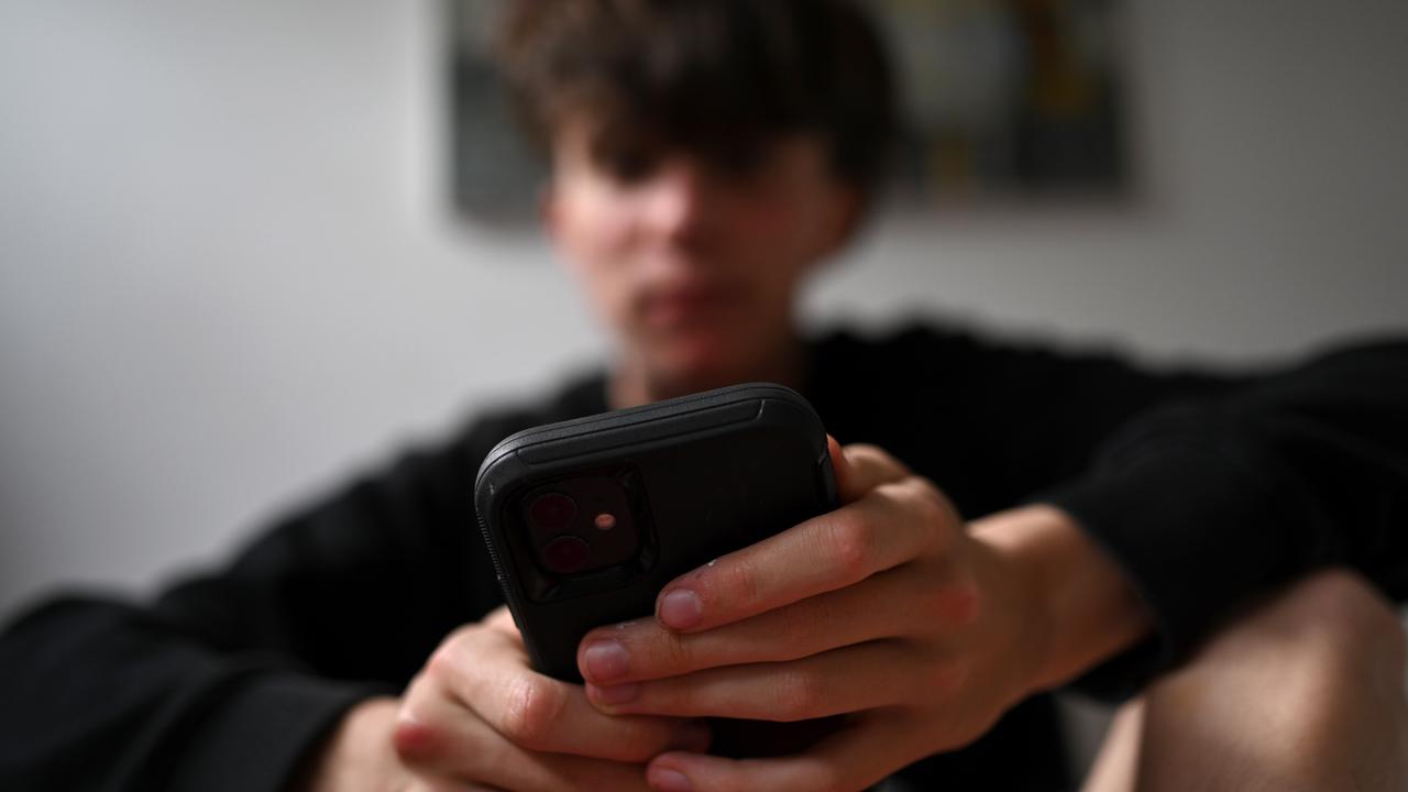 A teenager uses his mobile phone