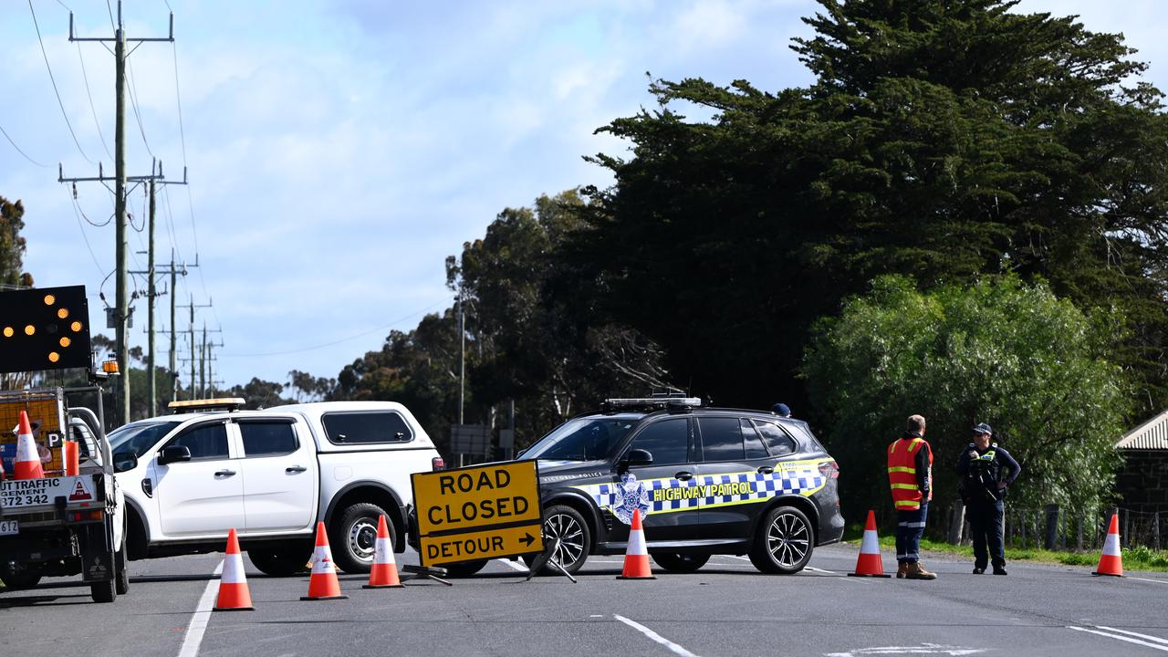 Police at a road block leading to the scene of a fatal bus accident
