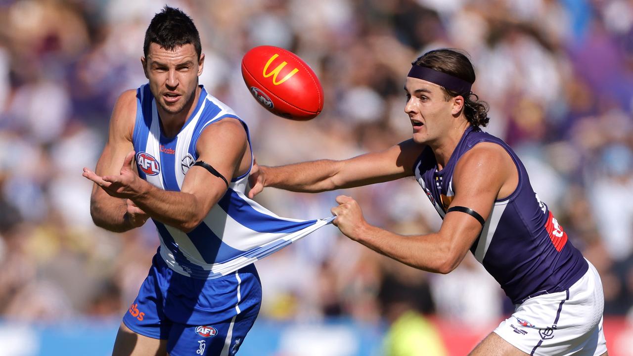Luke Davies-Uniacke handballs under pressure from Murphy Reid.