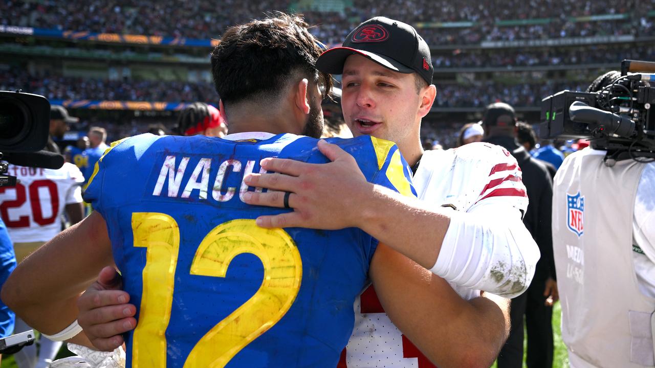 Brock Purdy (right) embraces the Rams' Puka Nacua