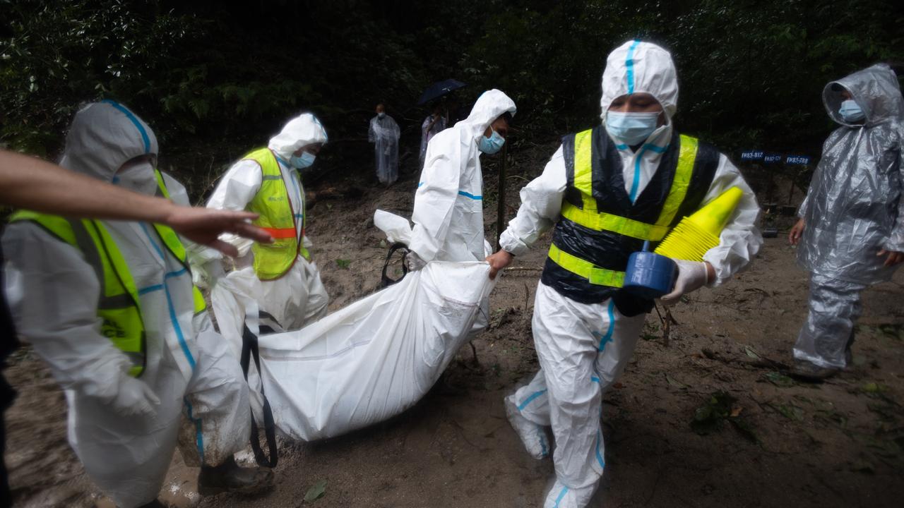 Army and police officers carry the bodies of unidentified victims