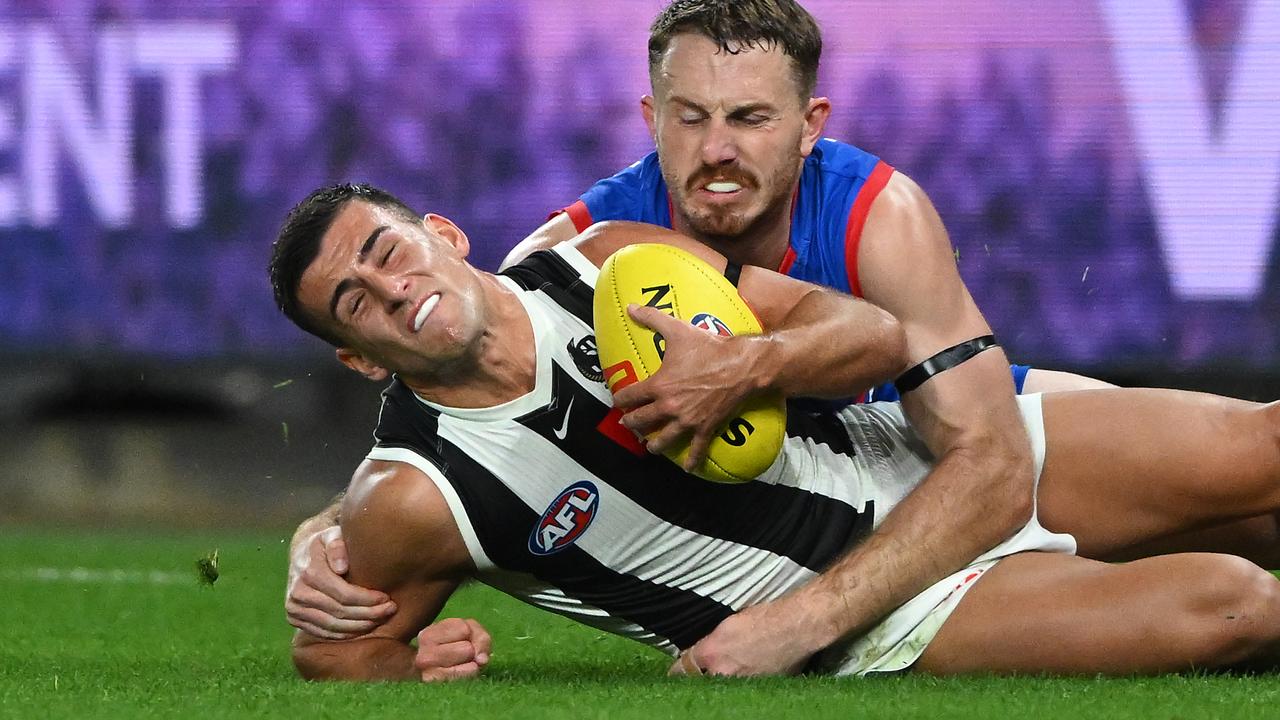 Nick Daicos of Collingwood (left) is tackled by Will Lewis