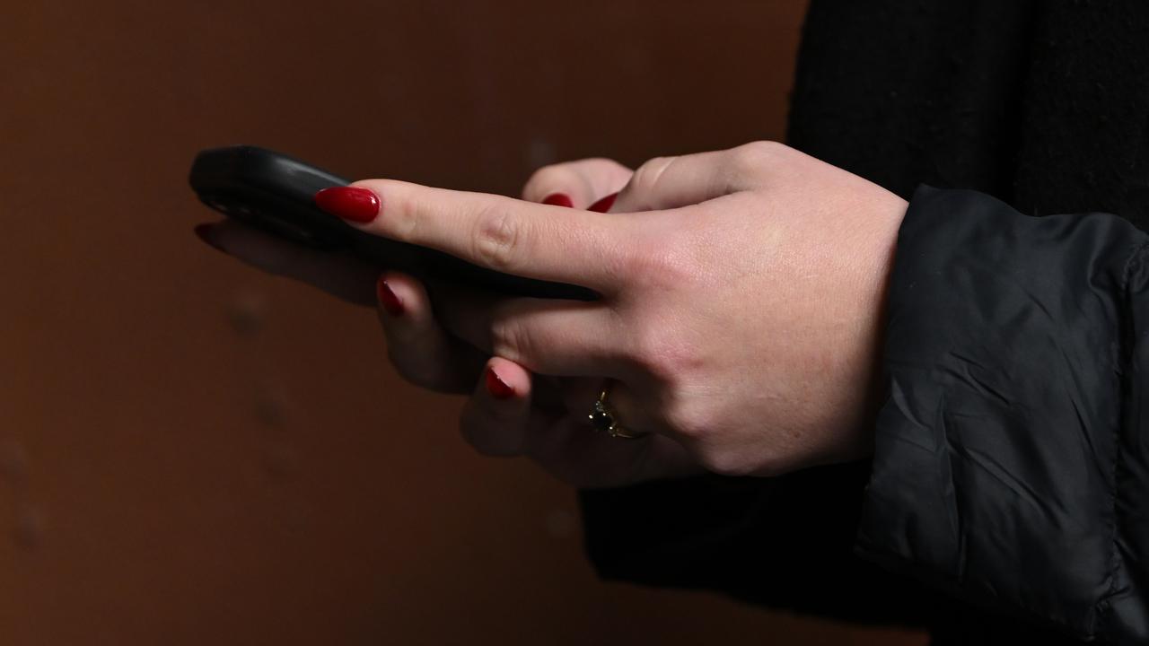 close-up image of a woman holding a phone in her hand