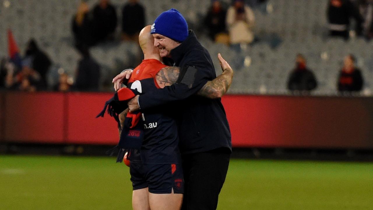 Neale Daniher embraces Melbourne's Nathan Jones.